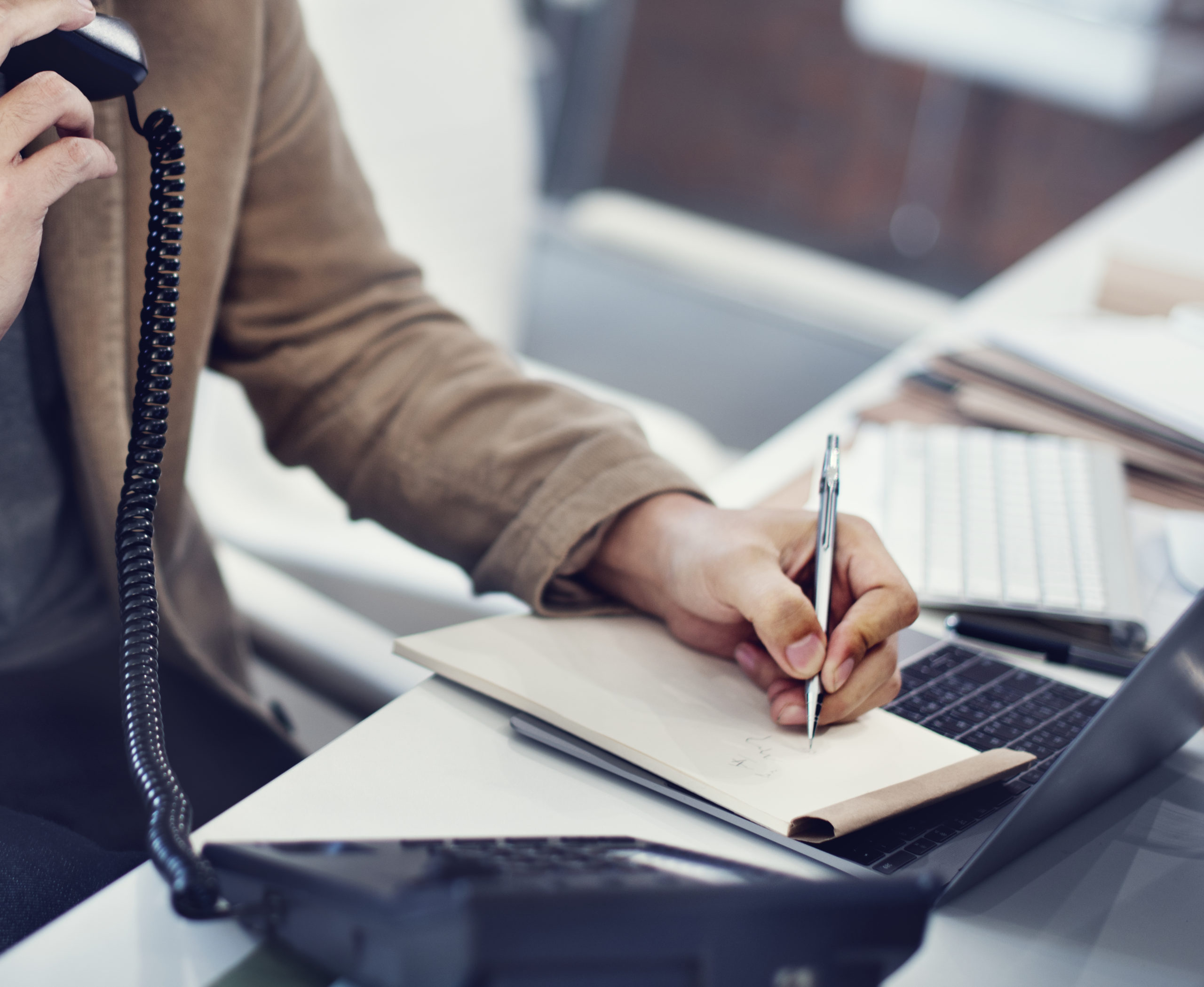 una person fa gli appunti mentre parla al telefono